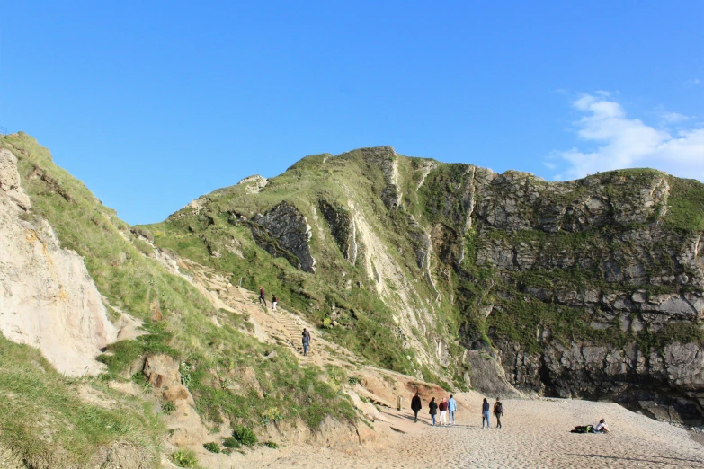 a group of people standing at the edge of a cliff with a surfboard next to them