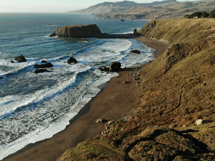 a rocky beach near the ocean on a sunny day