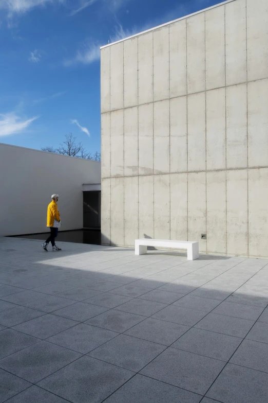 an empty room with cement walls and a person walking