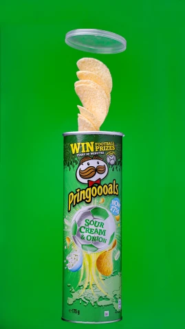 an open container of potato chips on green background