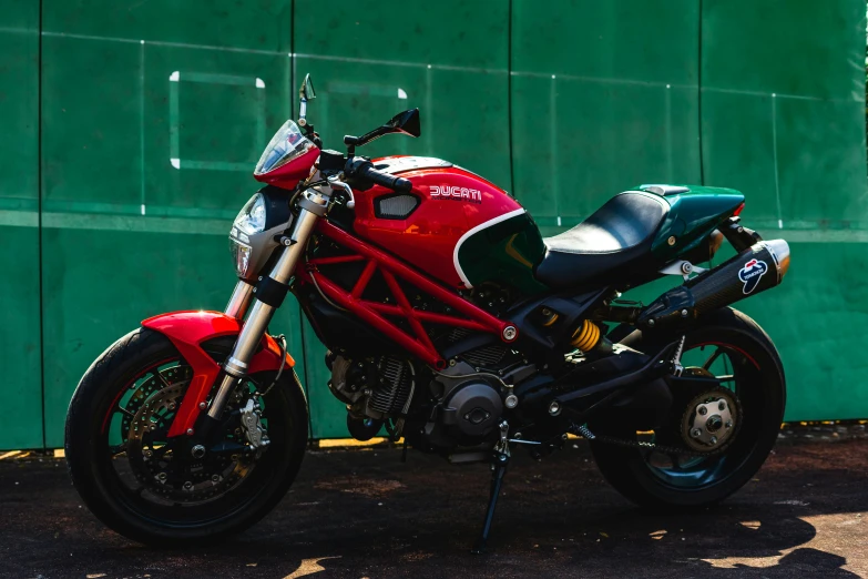 the motorcycle is parked near the green wall