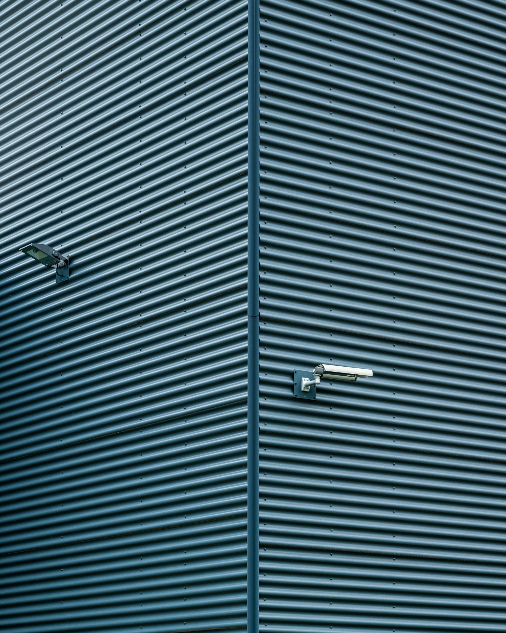 the corner of a building has blue, striped walls