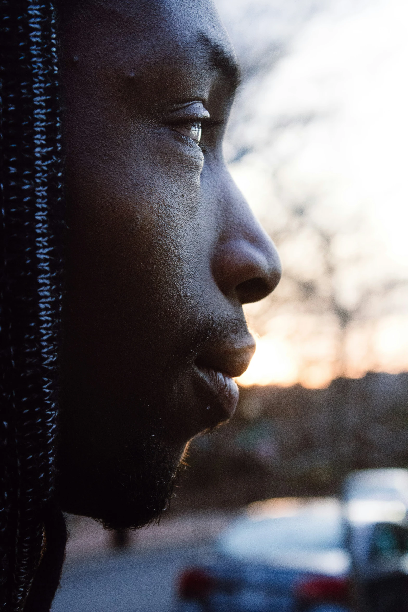 a man with dreadlocks stares in the distance