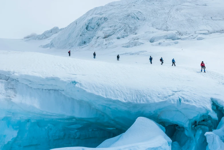 a group of people hiking through snow covered mountains