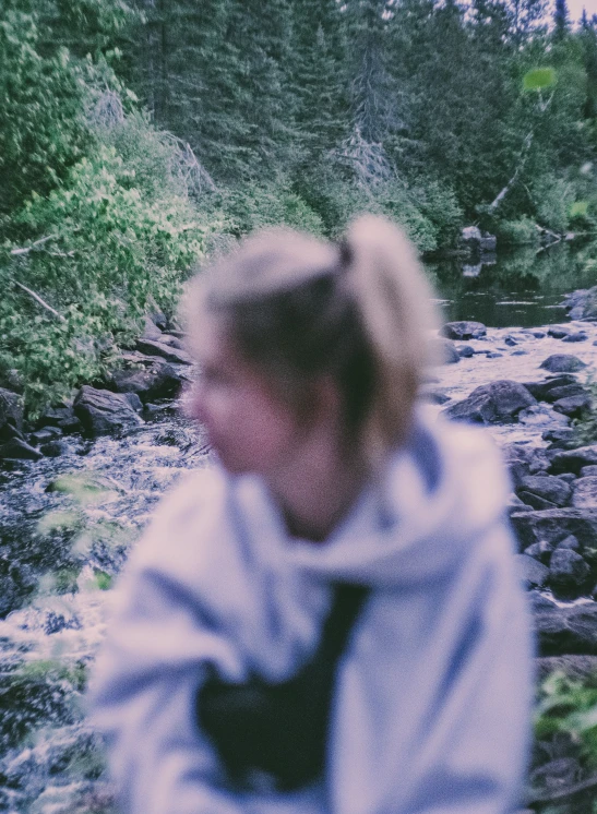 a person walking by a stream in a fur coat