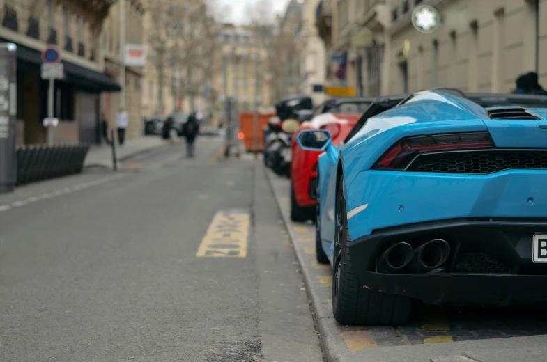 blue sports cars parked along the side of a street