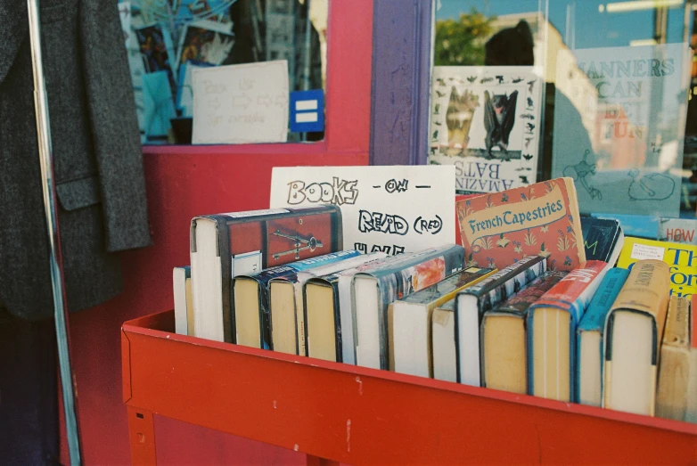 rows of open books in a stand, outside a book store