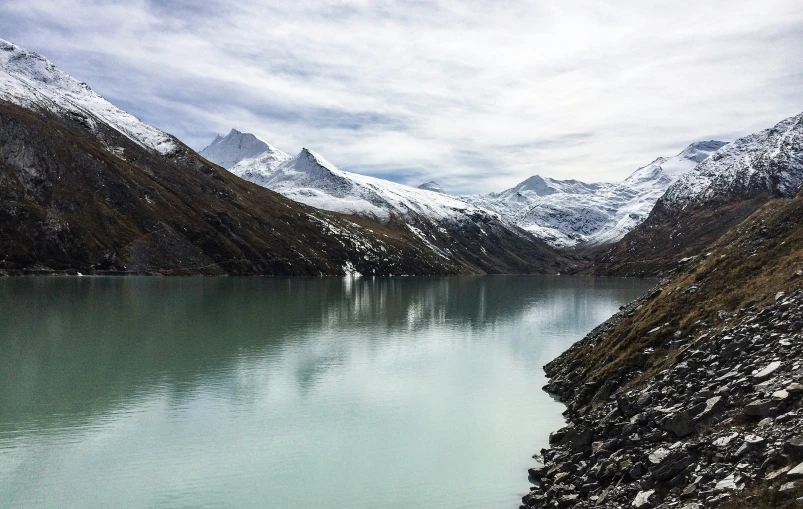 a mountain lake near an evergreen covered hillside