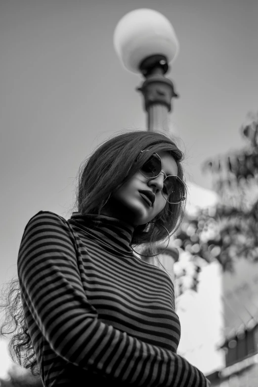 a woman in sunglasses poses on the street