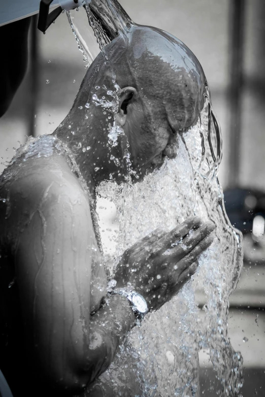 a man that is under a water faucet with his hands