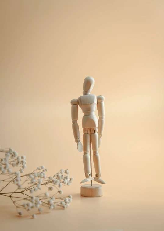 a wooden toy is standing on a small flower stem