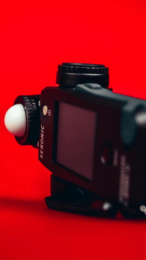 a black camera on top of a red table