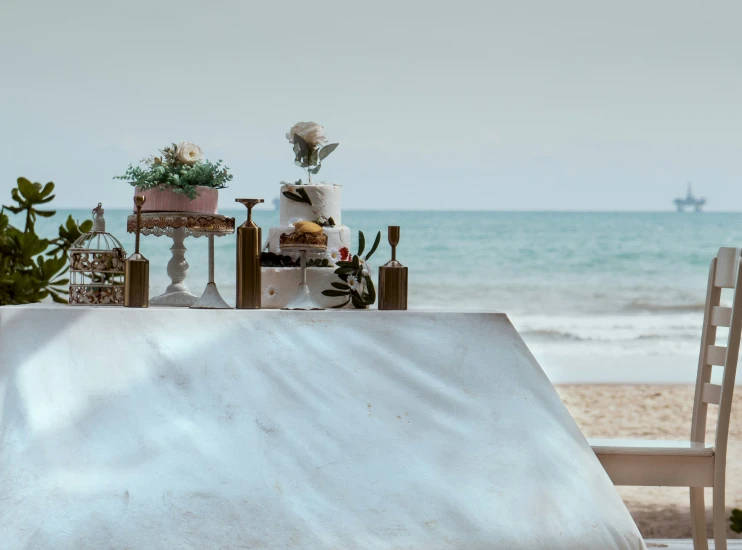 the beach has a table with pots and planters on it