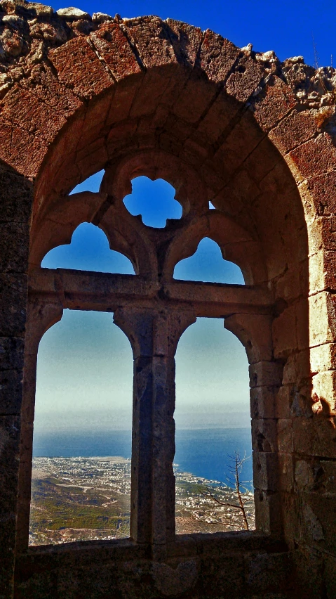 an arch is framed by arches with the ocean in the background