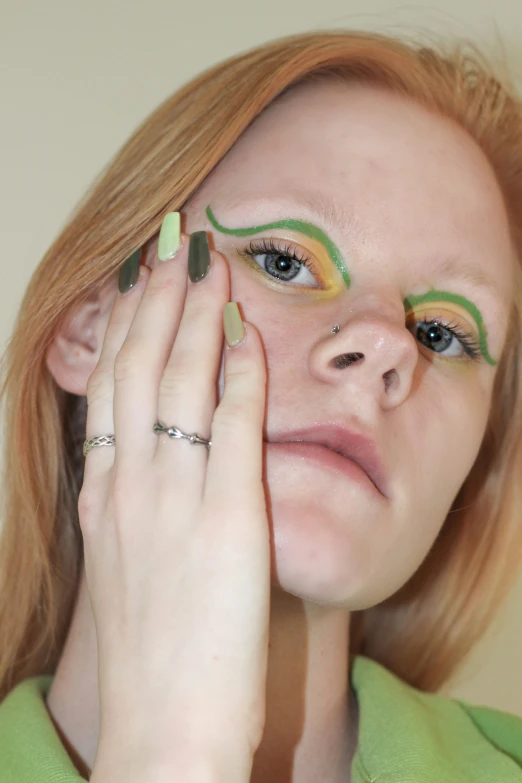 a woman with eye shadow and green eyeliner