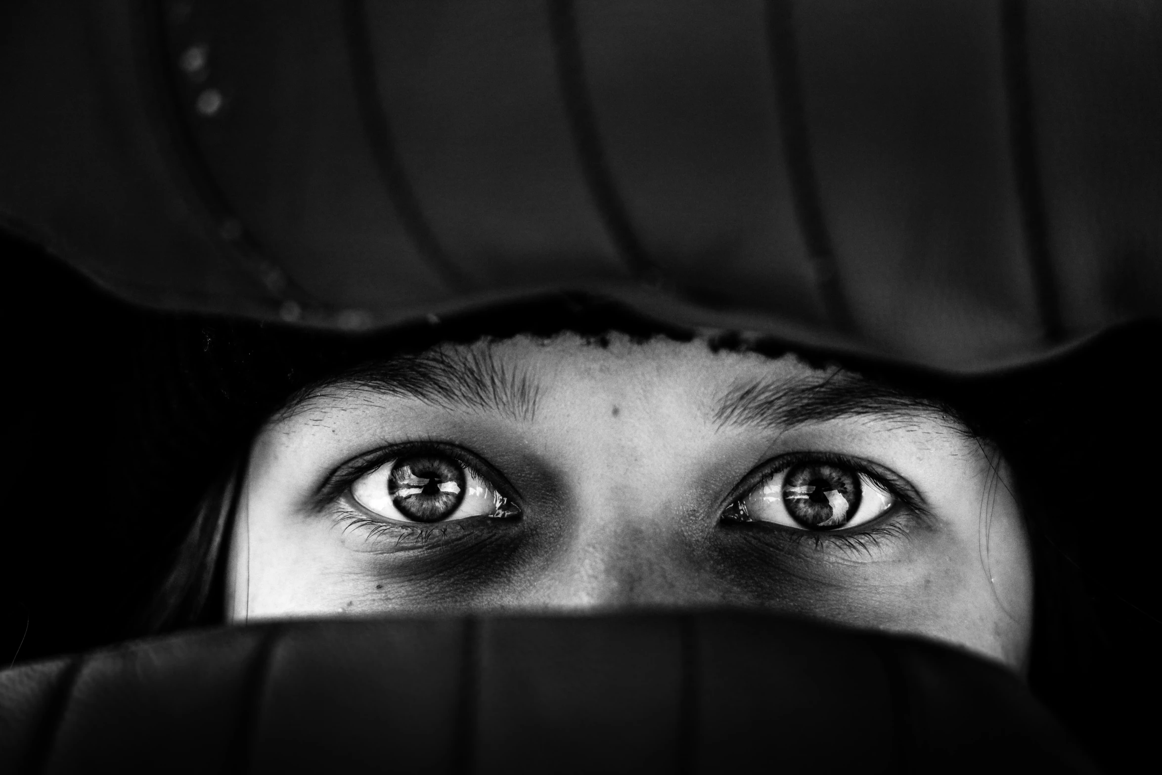 a woman is peeking her head through the fabric