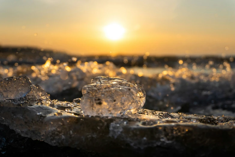 ice and ice crystals on the sand at sunset