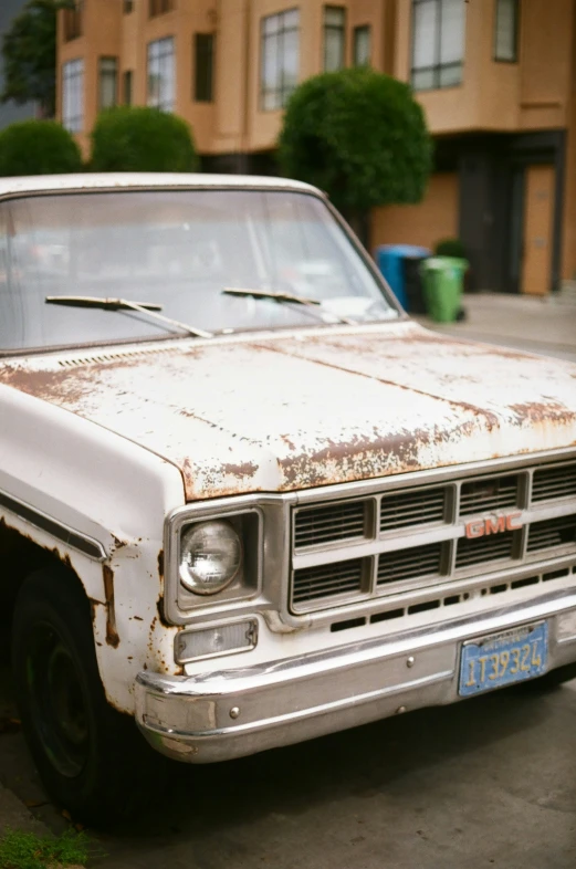 an old pick up truck is shown parked in front of some houses