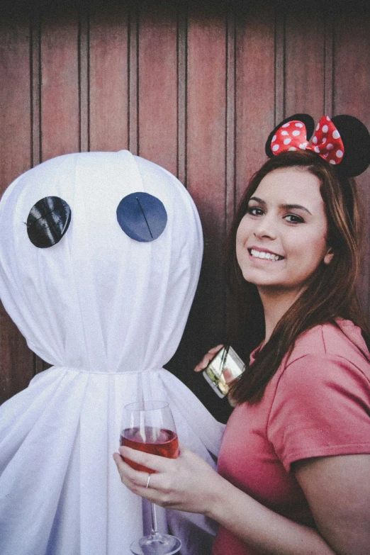 woman holding wine glass and boozie with smiling ghost in background