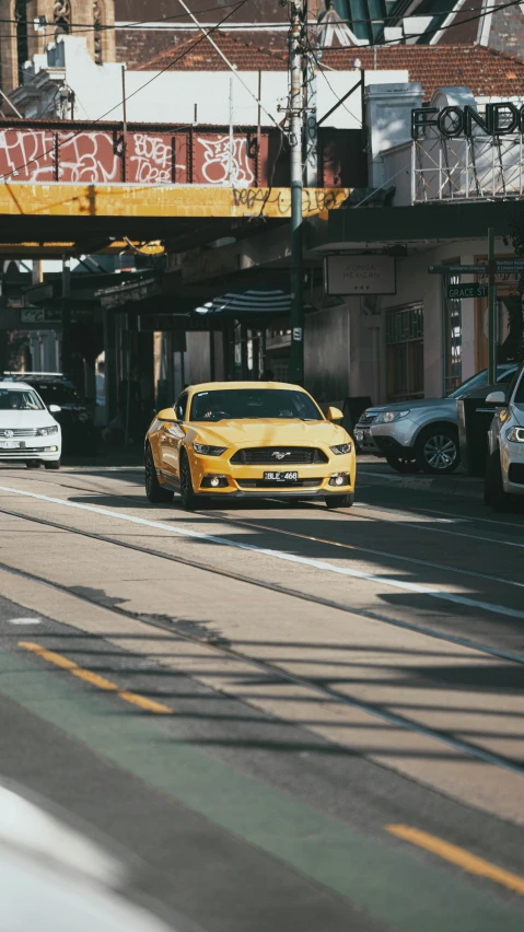 two yellow mustang cars parked near one another