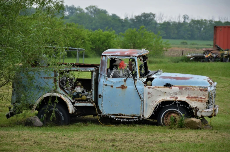 an old truck parked on a field of grass