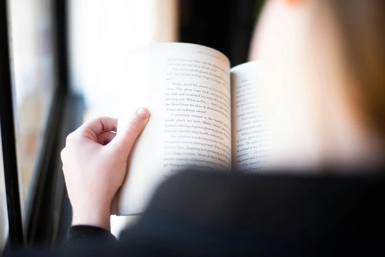 a woman holding an open book in her hands