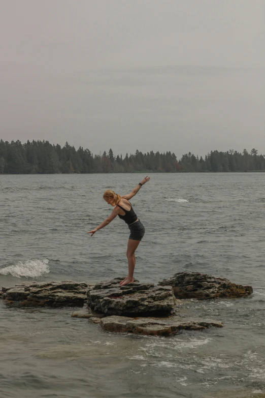 the  is balancing on the rock in the water