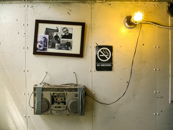 a small radio in front of an old wall light