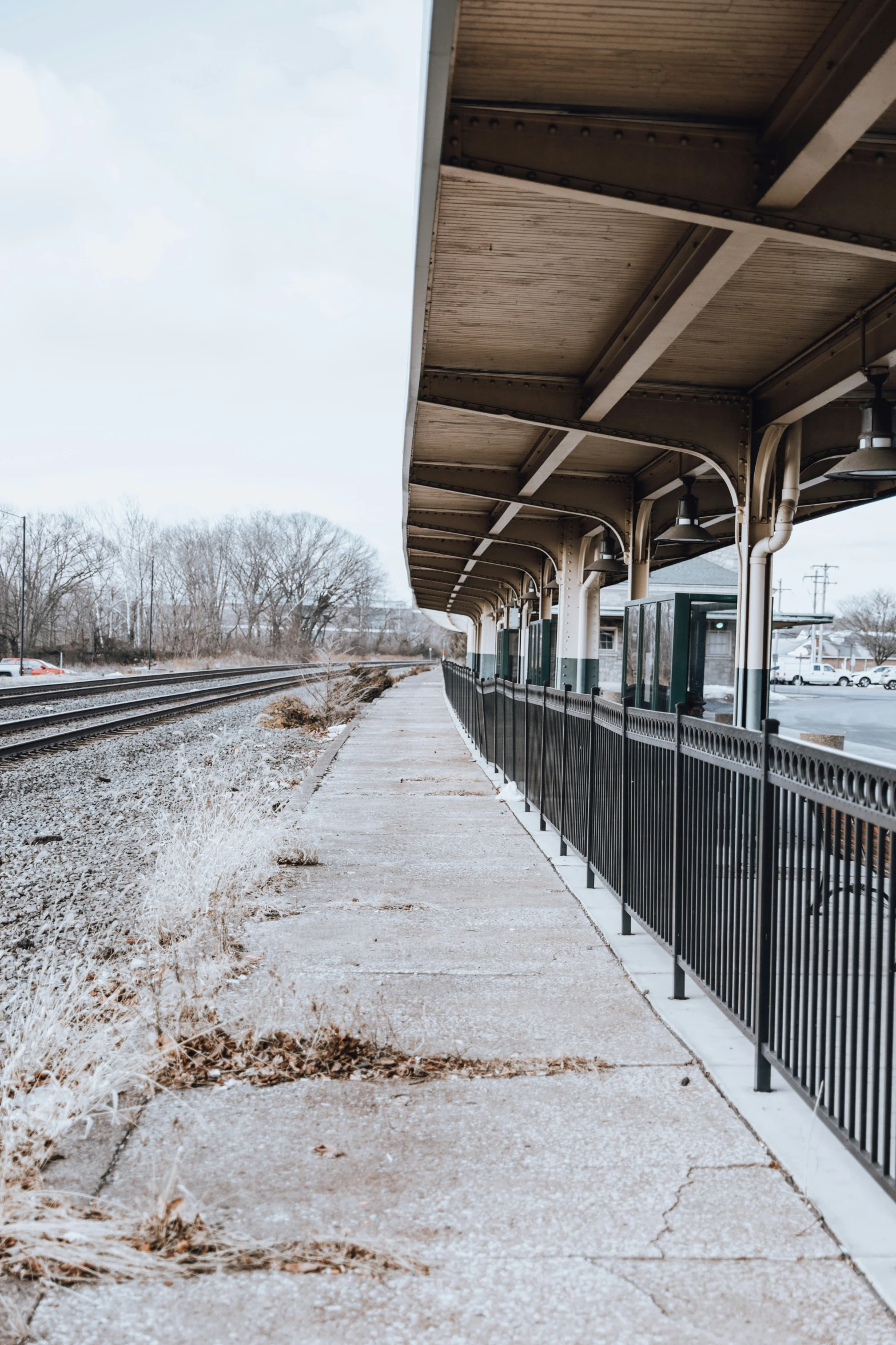 a covered rail bridge next to a train track