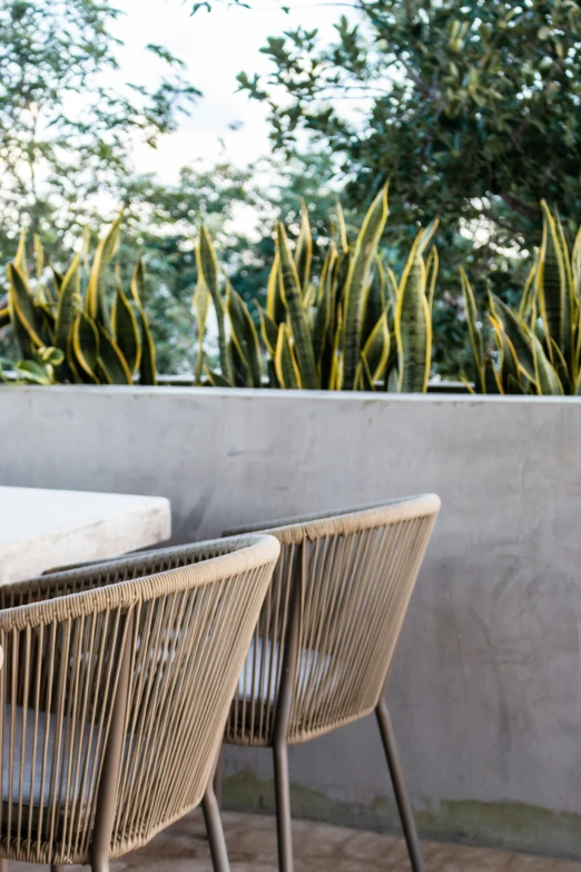 several different wood chairs with metal legs and seat cushions sitting next to each other on a deck