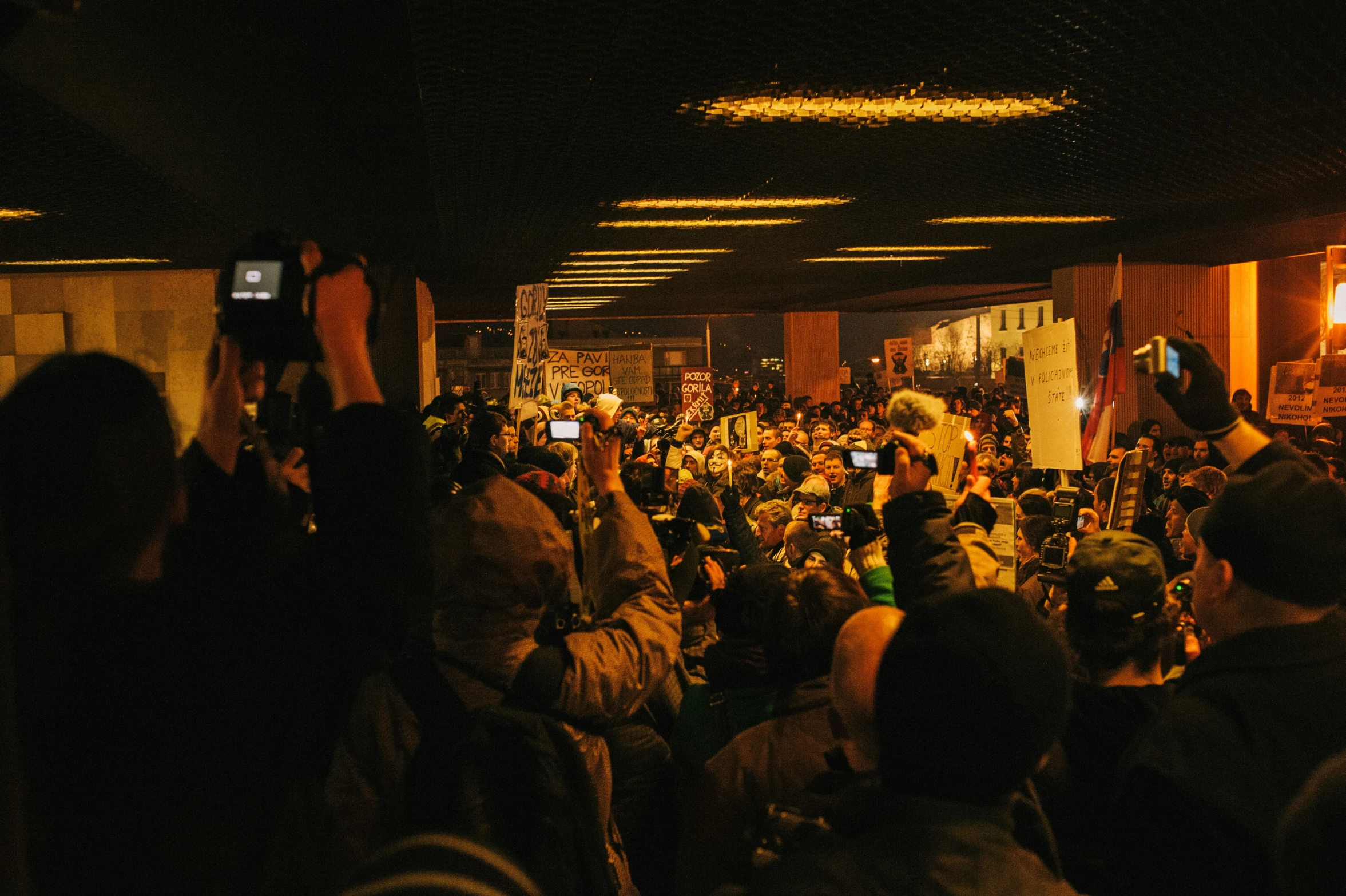 a large crowd of people taking pictures at night