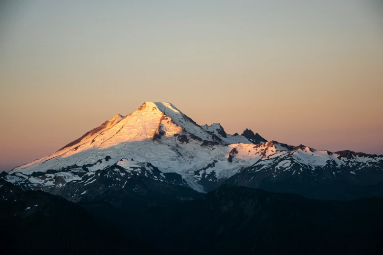 a snow covered mountain and its snow capped peak