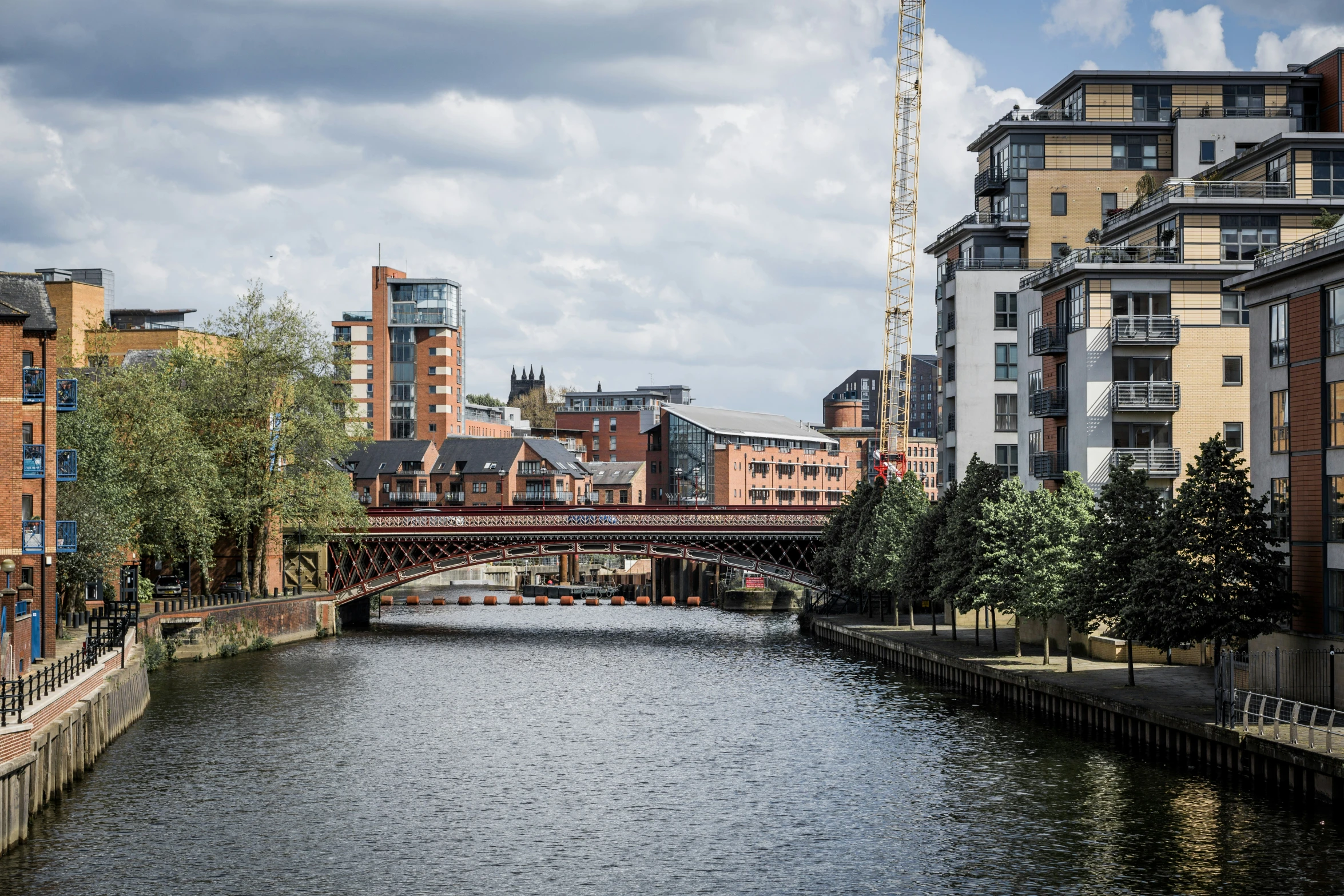 river with bridge and trees along it surrounded by buildings