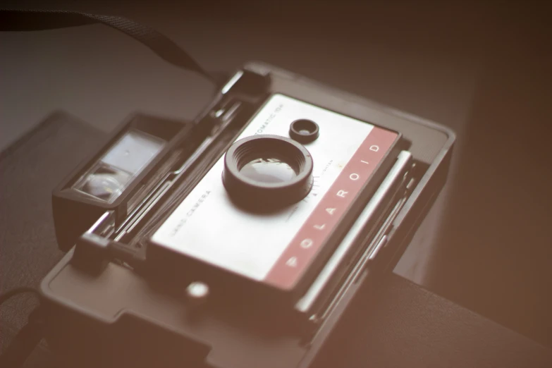 a phone sits next to a polaroid camera