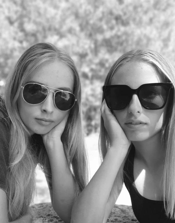 two women who are both wearing sunglasses on a hill