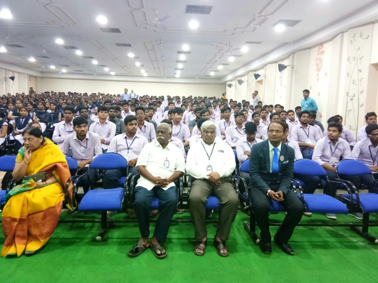 men in white shirts and ties sit in chairs near each other