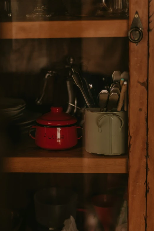 a shelf with a pan and many cooking tools
