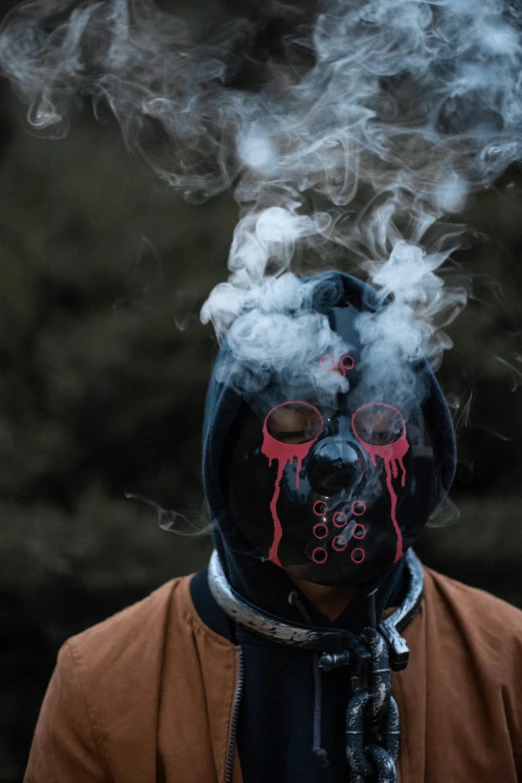 a man in a black mask with pink and red smoke coming out of it