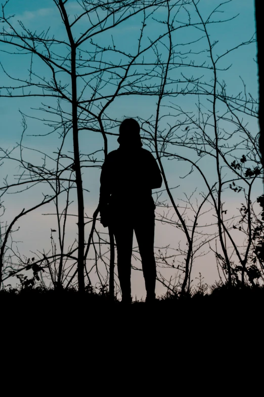 a person in silhouette standing next to some tree nches