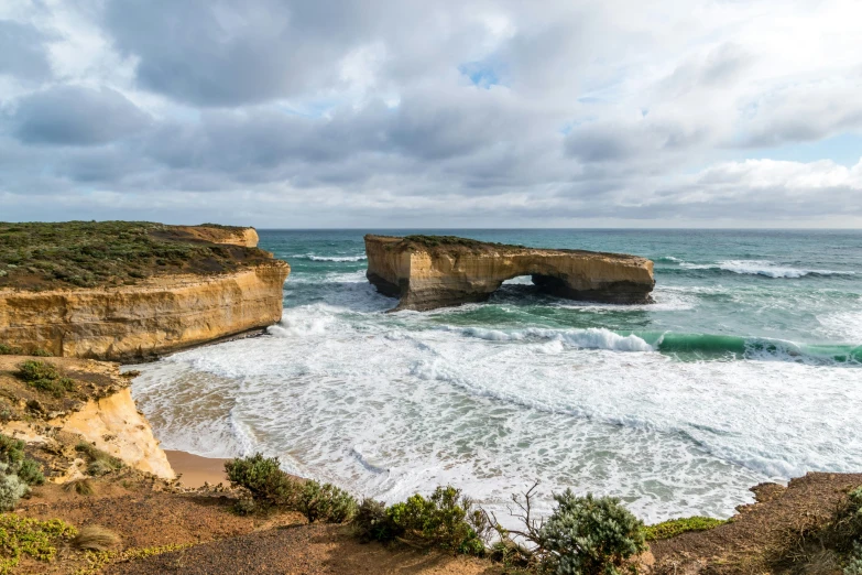 waves crashing in to shore with an arch formation