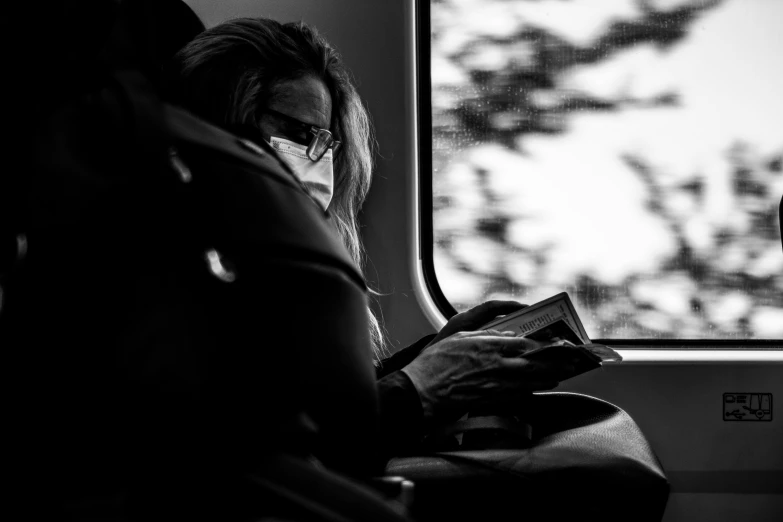 black and white image of a woman sitting on a bus