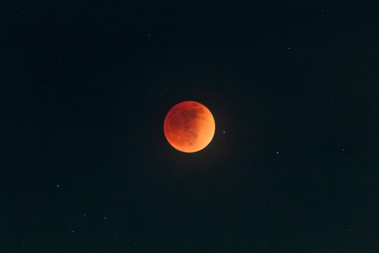 an orange eclipse eclipse from a dark sky