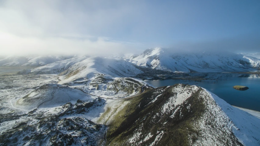 a mountain view with snow on the ground and blue sky above