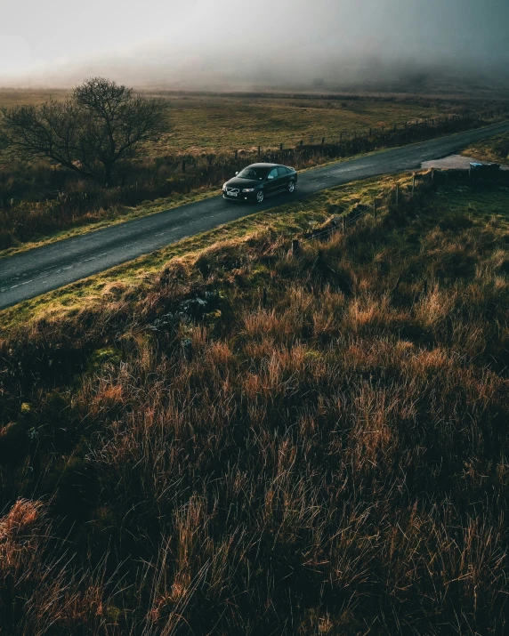 a car driving down the road in an open area