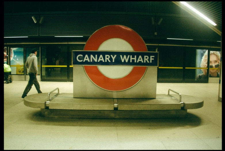 a sign reading canary wharf is displayed on the platform