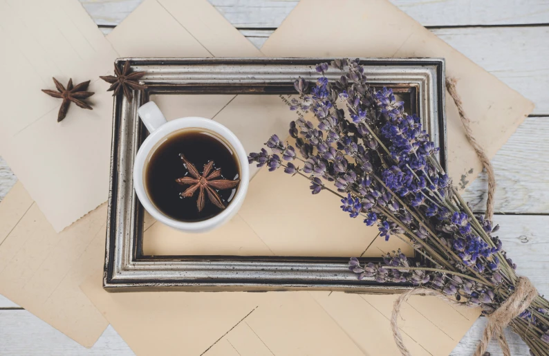 some lavender flowers in a mug and an old picture frame