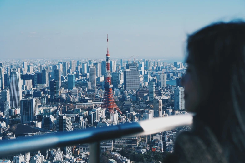 woman with cell phone standing in front of a city