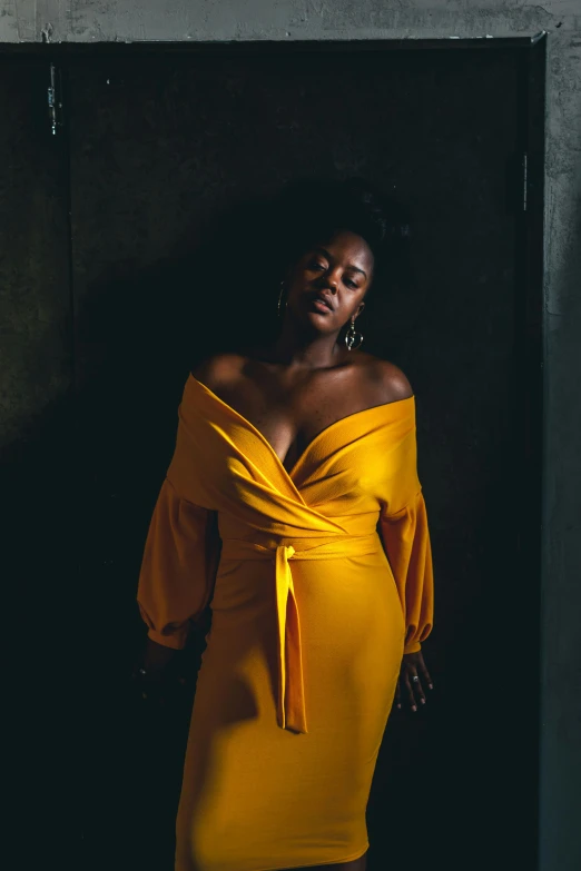 a black woman wearing a mustard colored dress is posing