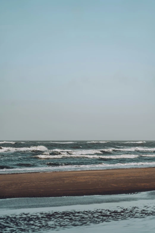 person on beach in water with surfboard