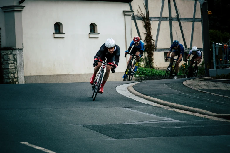 three men in helmets racing down a road